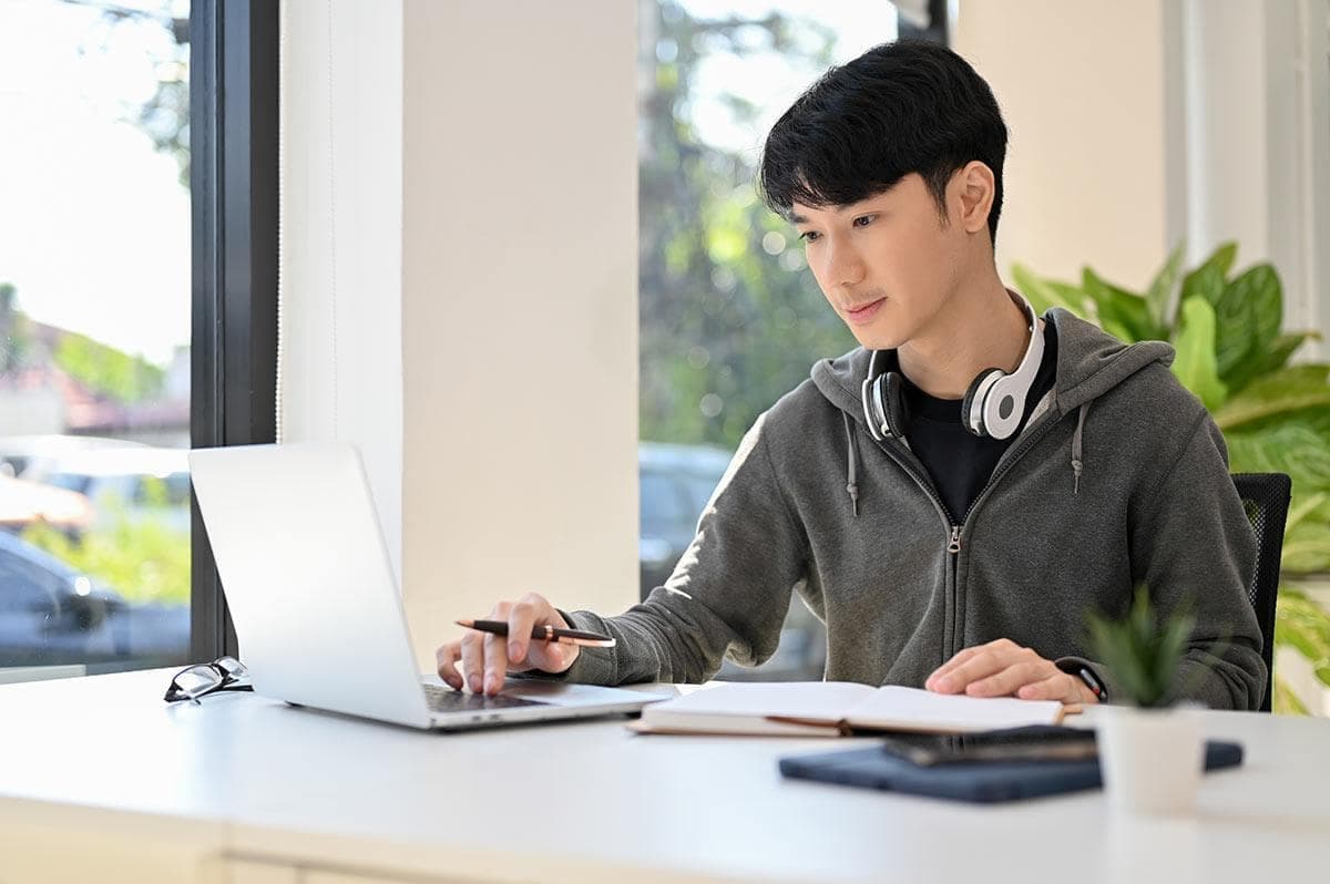 Student studying with laptop and books